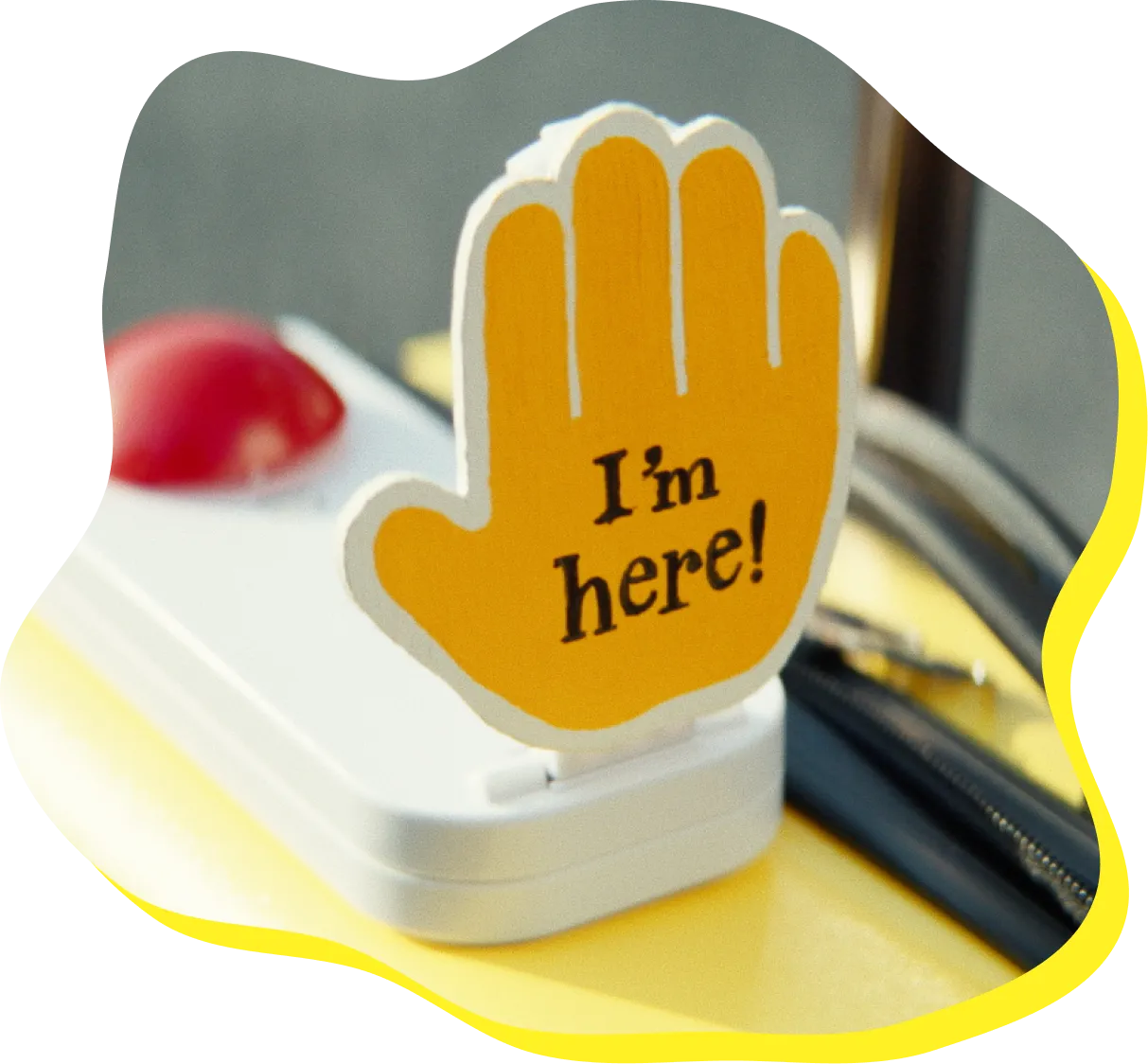 黄色い手の形の小道具に「I’m here!（ここにいるよ！）」と書かれている